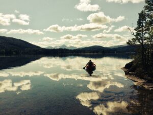 Kanopadler på Aven der skyene speiler seg i vannet