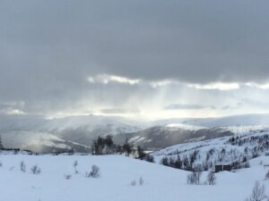 Solskinn bryter gjennom skydekket og lyser opp fjellene