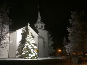 Korgen kirke flombelyst og med snø i trærne