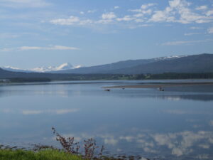 Båter på Sørfjorden med snøkledde fjell i bakgrunnen